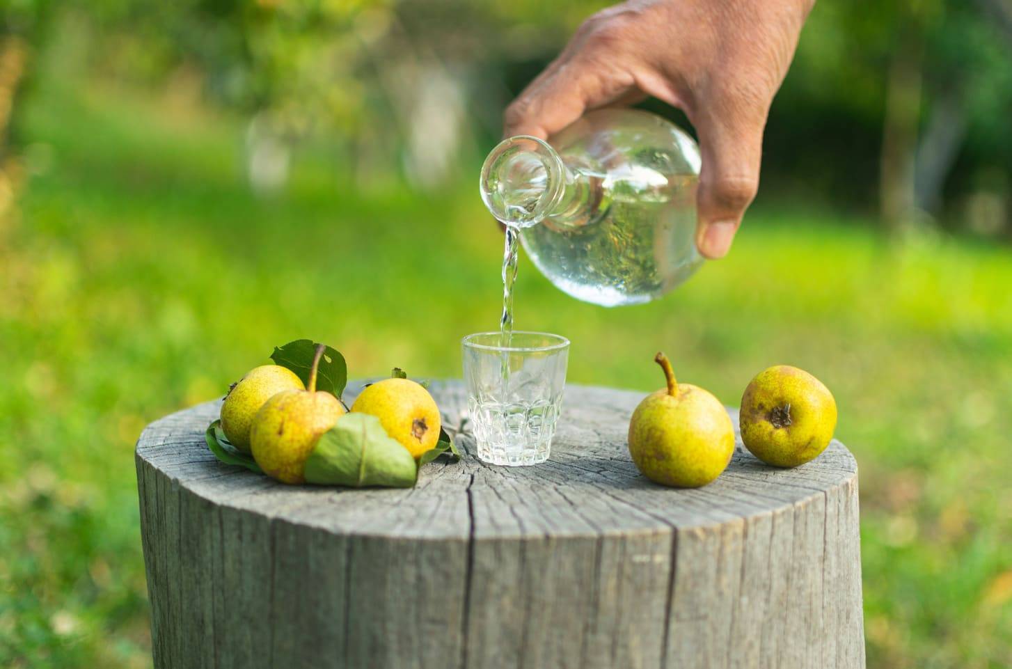 Traditional pear rakia being poured in the Balkan countryside – part of our small group cultural tours